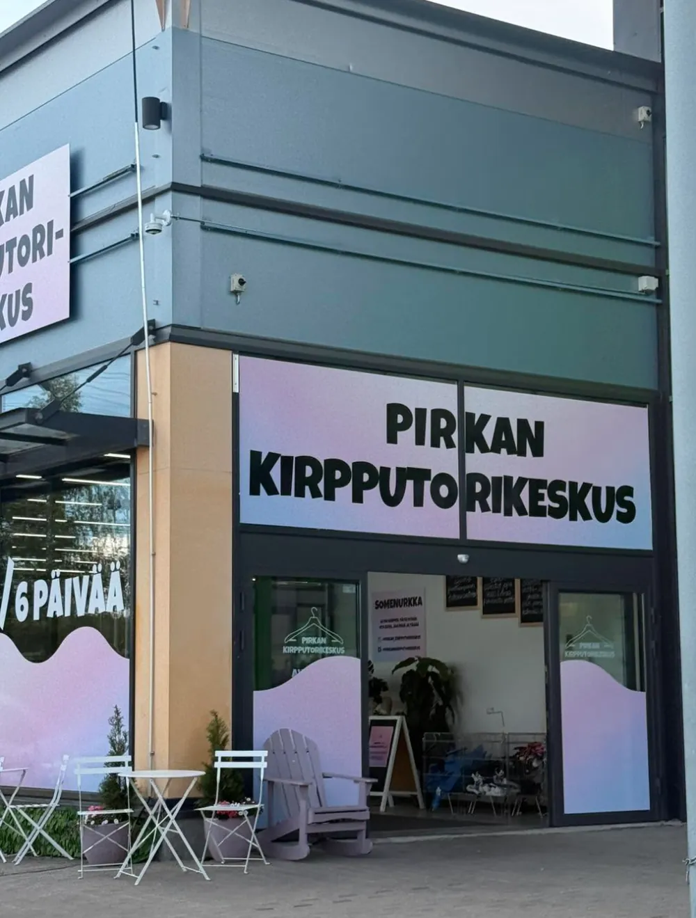 Pirkan Kirpputorikeskuksen sisäänkäynti: vaaleanpunaiset ikkunateippaukset ja nimikyltti oven yläpuolella.